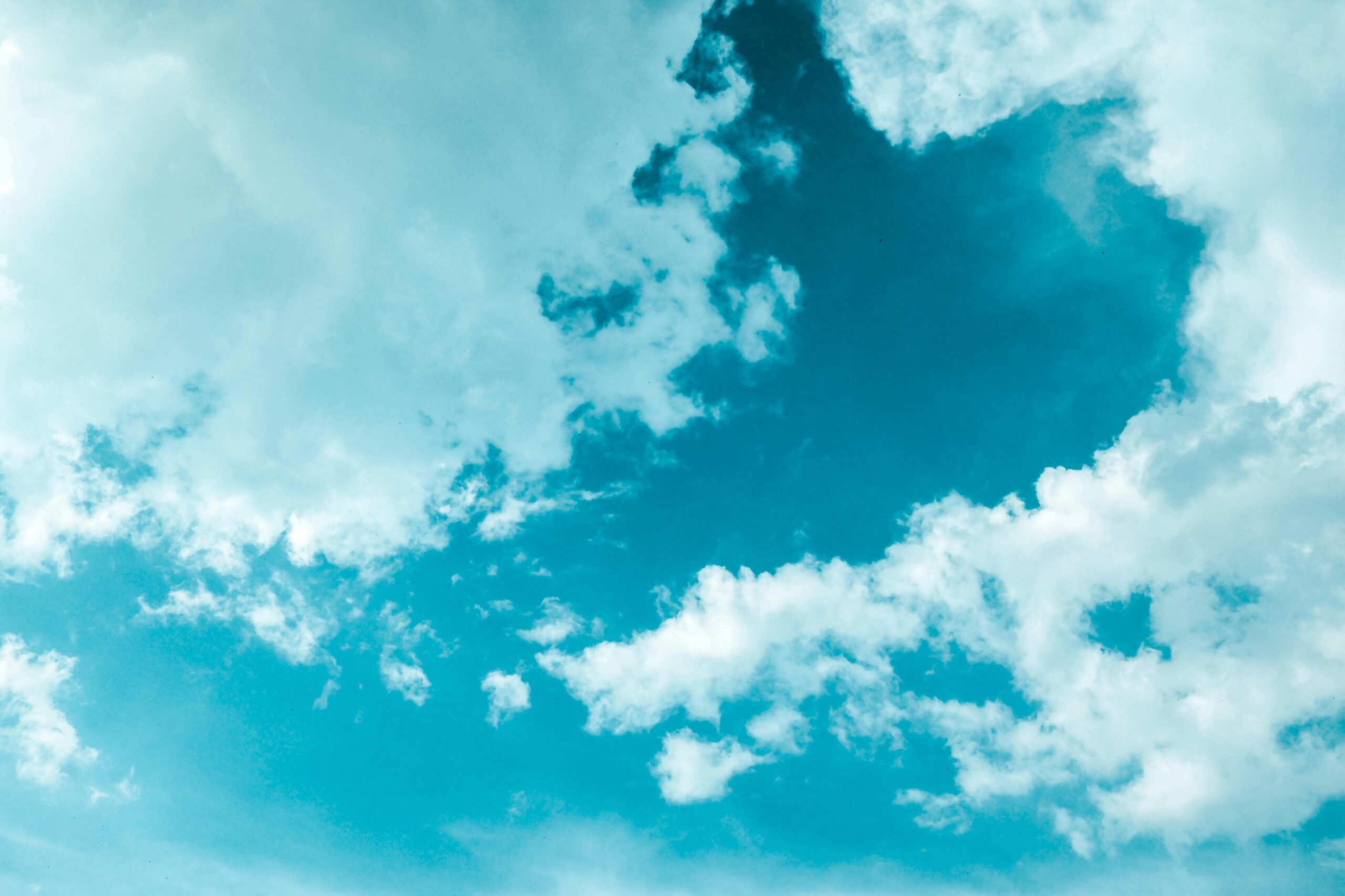 A vibrant scene of cumulus clouds floating in a bright blue sky, creating a serene and dreamy atmosphere.