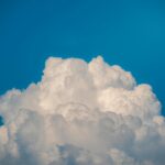 Cumulus clouds rising high in a clear blue sky, showcasing nature's beauty.